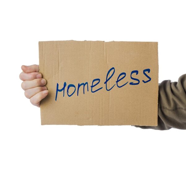 Homeless person holding cardboard sign